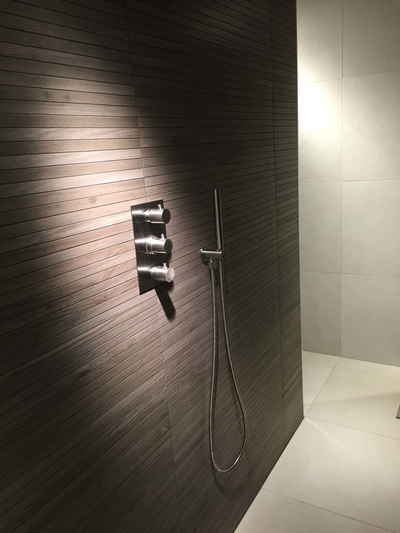 Luksus badeværelse med brusekabine med lækkert træ-look og moderne, elegante bruseelementer